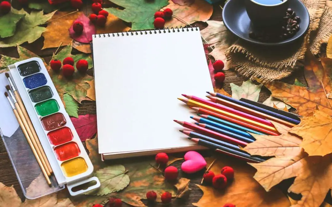 A stationery and a cup of coffee, on a background of autumn leaves.