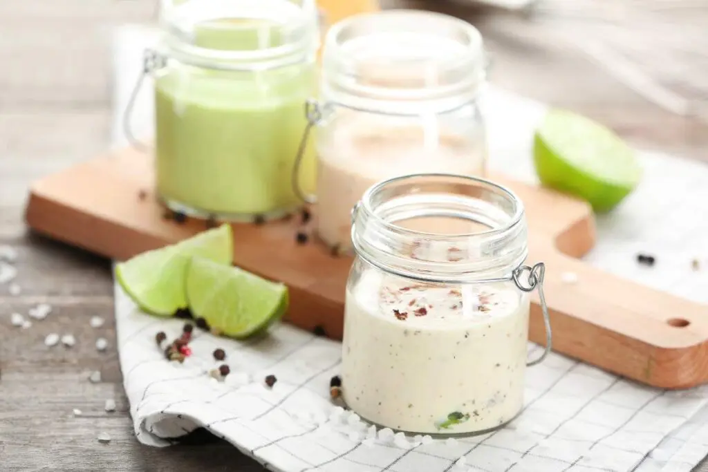 Three small glass jars are filled with different sauces.