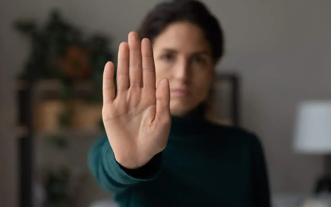 A woman is holding her palm up with a no gesture.