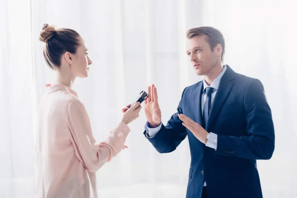 A man in business attire is rejecting a woman asking for an interview.