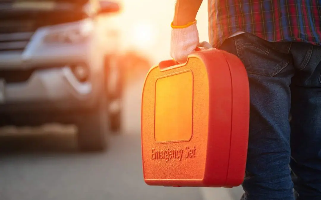 A person standing outdoors on the street, carrying a red box in their hand.