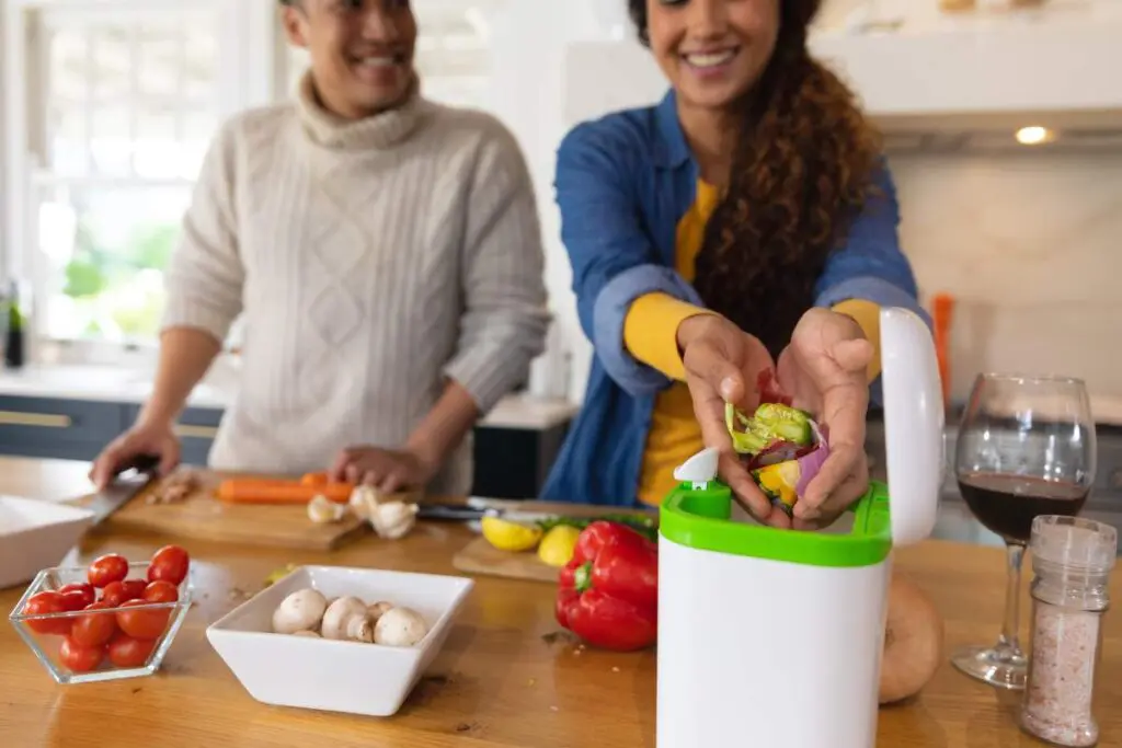 A man and woman chop vegetables together in a bright kitchen.