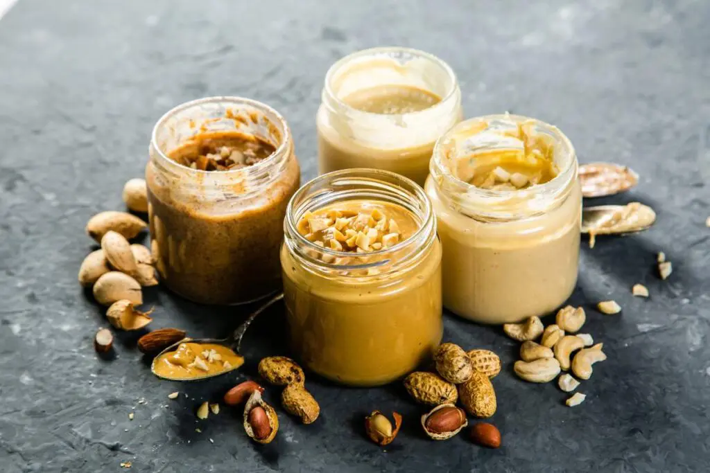 A group of assorted jars of peanut butter arranged on a table.