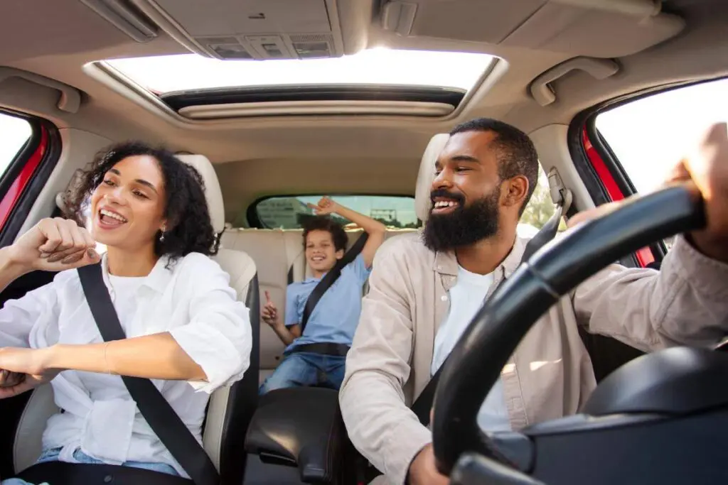 Three passengers inside a car enjoying their ride.