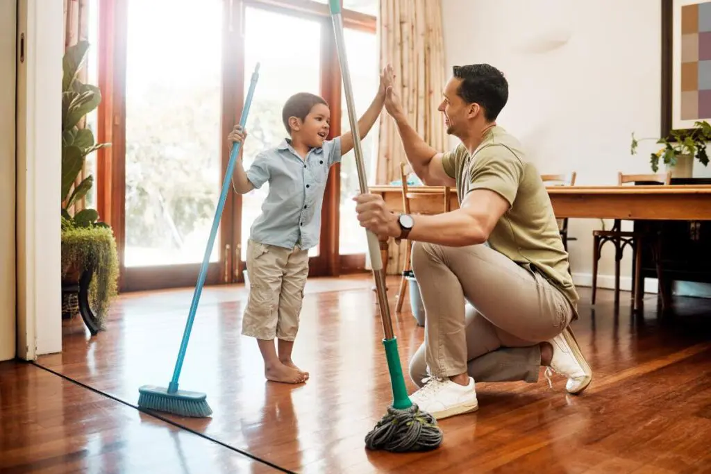 A man and a young boy are cleaning a room together.