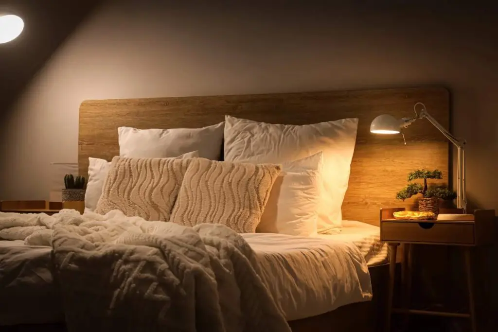 A cozy bedroom scene featuring a neatly made bed with white pillows and a textured blanket.