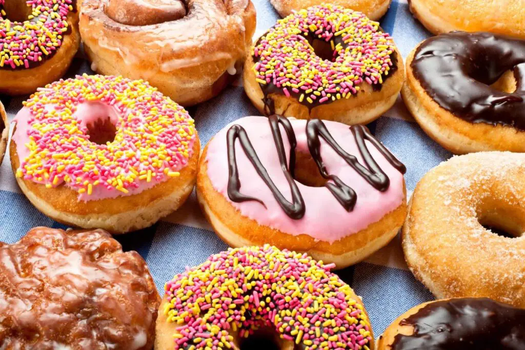 A variety of donuts, including frosted, sprinkled, and glazed options.